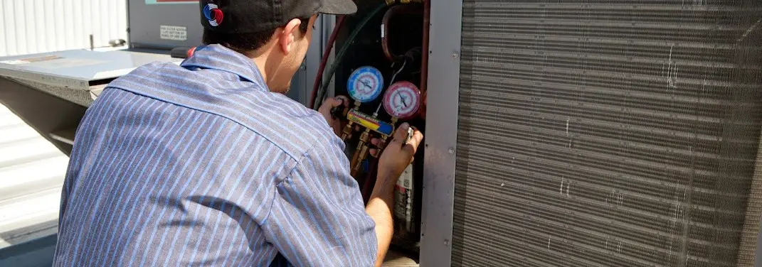 HVAC technician servicing a condenser unit in Belgrade